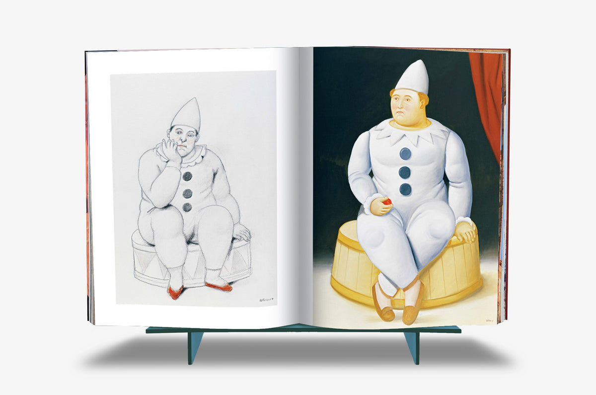 Fernando Botero XXL by Assouline: Book open to a Pierrot spread — a pencil sketch of a pensive, rotund clown in a conical hat seated on a drum on the left, paired with the finished oil painting of the same Pierrot in white costume with large round buttons against burgundy drapery on the right.